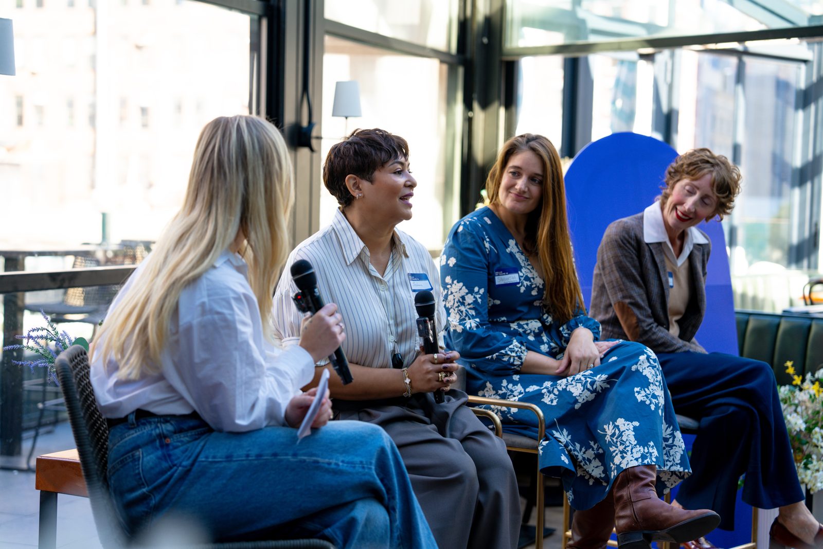 Stephanie speaking on a panel with three other women in a sunlit room